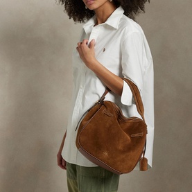 Model carrying Polo Ralph Lauren Satchel in Cinnamon/Cuoio suede, worn over shoulder, styled with white shirt and khaki trousers