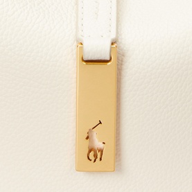 Polo Ralph Lauren ivory shoulder bag close-up of gold-tone hardware tag with embossed polo player logo and white leather strap