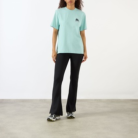 Model wearing Adanola Logo Graphic Oversized T-Shirt in Ocean Blue with black flared trousers and chunky trainers.
