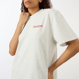 Model wearing Adanola Logo Graphic Oversized T-Shirt in Light Grey Melange with red logo print, round neck and short sleeves.