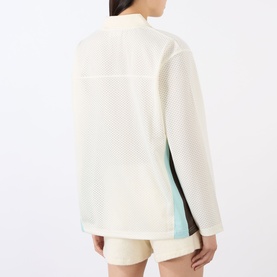 Model wearing Adanola top in Marshmellow White, open-knit mesh fabric, back view, styled with cream shorts and mint side-stripe detail.