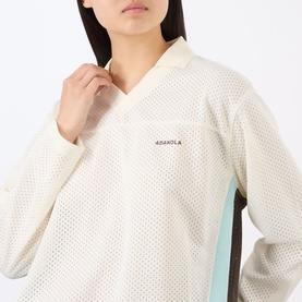 Model wearing Adanola top in Marshmellow White, featuring mesh fabric texture and V-neckline with long sleeves and mint blue side panel detail.