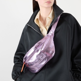 Model carrying Anxious Preoccupied The Oversized Belt Bag in lilac metallic finish, gold-tone hardware, orange contrast zip pull, worn crossbody over