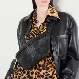Model carrying Anxious Preoccupied The Oversized Belt Bag in black with gold-tone hardware, worn crossbody over black leather jacket and leopard