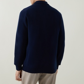 Model wearing Aspesi Blue Knitted Polo Shirt, rear view, long sleeves, polo collar, 100% wool, styled with light beige trousers