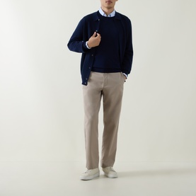 Model wearing Aspesi Blue Knitted Polo Shirt cardigan with beige trousers, light blue shirt, and white trainers.