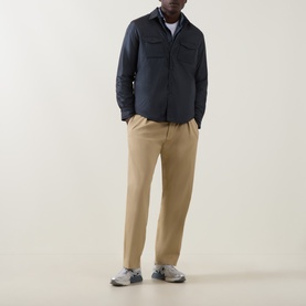 Model wearing Aspesi navy nylon casual jacket with chest pockets, styled with beige trousers and grey trainers