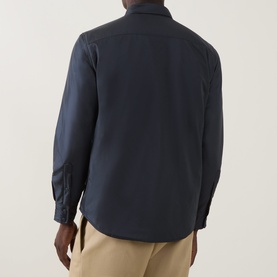 Model wearing Aspesi navy nylon casual jacket, shown from behind, styled with beige trousers