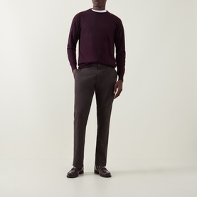 Model wearing Aspesi Fine-Knit Sweater in burgundy wool with crew neck and ribbed trims, styled with dark trousers and loafers.