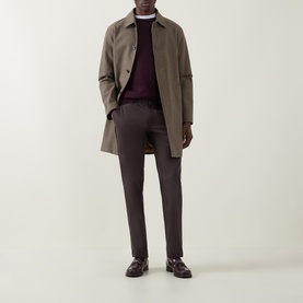 Model wearing Aspesi Burgundy Fine-Knit Crew Neck Sweater, styled with a taupe mac coat and dark charcoal trousers.