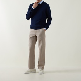 Model wearing Aspesi Solid Wool Sweater in Black Navy with crew neck, paired with beige trousers and white trainers.