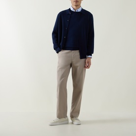 Model wearing Aspesi Solid Wool Sweater in Black Navy over light blue shirt, styled with beige trousers and white trainers.