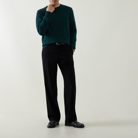 Model wearing Aspesi Solid Wool Sweater in green with crew neck, paired with black wide-leg trousers and black leather shoes.