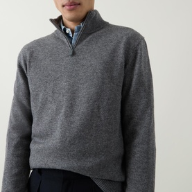 Model wearing Aspesi Solid Half-Zip Sweater in grey with funnel neck and half-zip. Styled with blue check shirt and dark trousers.