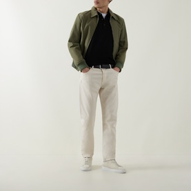 Model wearing Aspesi Solid Knitted Polo Shirt in black wool, styled with olive jacket, cream trousers and white trainers.