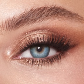 Charlotte Tilbury Eye Shadow in Oyster Twilight worn on a blue eye, blended bronze and champagne shimmer with defined lashes