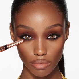 Model wearing Charlotte Tilbury Eye Shadow in Cashmere Sculpt, applied with a rose gold brush for a sculpted smoky eye look.