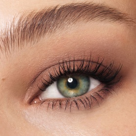 Close-up of model's eye wearing Charlotte Tilbury Eye Shadow in Cashmere Sculpt, a warm taupe smoky look with voluminous lashes