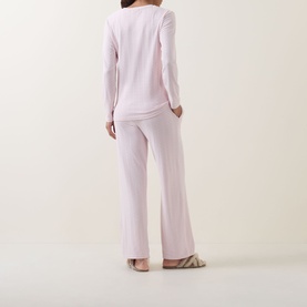 Model wearing Gingerlilly Ellie Lightweight Velour Cable Knit Pyjama Set in Ellie Pink, rear view, with wide-leg trousers and long-sleeve top.