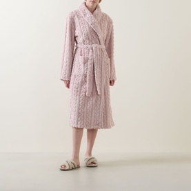 Model wearing Gingerlilly Gabriella Plush Long Robe in Gabriella Pink, cable-knit pattern, shawl collar, self-tie belt, styled with cream slippers