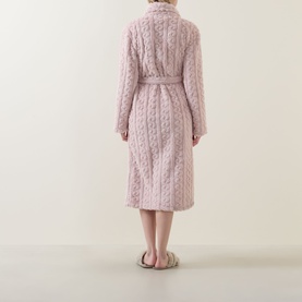 Model wearing Gingerlilly Gabriella Plush Long Robe in Gabriella Pink, cable-knit pattern, self-tie belt, shown from behind with fluffy slippers