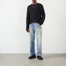 Model wearing Our Legacy True Knitted Sweater in Black Cloud Cotton with light wash distressed jeans and black chunky loafers.