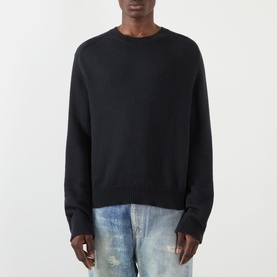 Model wearing Our Legacy True Knitted Sweater in Black Cloud Cotton, crew neck, long sleeves, ribbed trims, styled with distressed jeans.