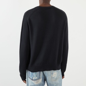 Model wearing Our Legacy True Knitted Sweater in Black Cloud Cotton, crew neck, ribbed trims, styled with distressed light-wash jeans.