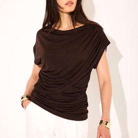 Model wearing Mint Velvet Brown Double Layer Drape Top with slash neckline, draped front detail and short sleeves, styled with white trousers