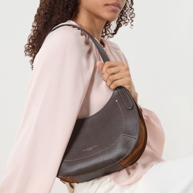 Model carrying Gianni Chiarini Gabry Shoulder Bag in brown grained leather with suede side panels and gold-tone hardware, worn over shoulder
