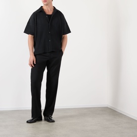 Model wearing Issey Miyake black short-sleeve casual shirt with black trousers and black leather shoes.