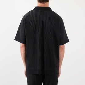 Model wearing Issey Miyake black pleated short-sleeve casual shirt, back view, styled with black trousers