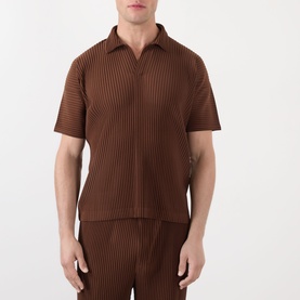 Model wearing Issey Miyake anchor brown pleated short-sleeve zip polo, styled with matching pleated trousers