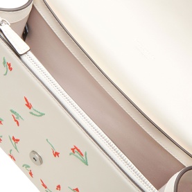 Kate Spade cream multi leather crossbody bag, open top view showing floral tulip print interior lining and silver zip detail