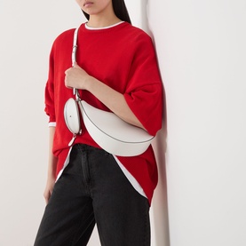 Model carrying Kate Spade Duo Pebbled Leather Crossbody Bag in True White with silver-tone hardware, worn crossbody. Styled with red oversized
