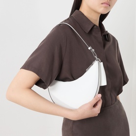 Model carrying Kate Spade Duo Mini Shoulder Bag in True White pebbled leather with silver-tone hardware, worn as shoulder bag. Styled with brown
