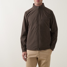 Model wearing Peter Millar Ryder 3-in-1 Jacket in Ash Brown, zip-up with stand collar, styled with beige chinos