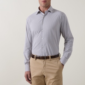 Model wearing Peter Millar black gingham casual shirt, styled with beige chinos and brown leather belt.