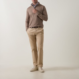Model wearing Peter Millar Light Mocha half zip knit, styled with a collared shirt, beige chinos, and white trainers.