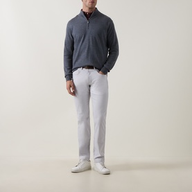 Model wearing Peter Millar Autumn Half-Zip Sweater in charcoal, styled with light grey trousers and white trainers.