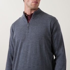 Model wearing Peter Millar Autumn Half-Zip Sweater in charcoal merino wool blend, with funnel neck and silver zip, styled over a burgundy collar.