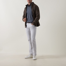 Model wearing Peter Millar Autumn Half-Zip Sweater in charcoal, styled with brown jacket, white trousers and white trainers.