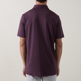 Model wearing Peter Millar polo shirt in Bordeaux, rear view, short sleeves, smooth stretch fabric with subtle collar detail visible.