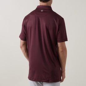 Model wearing Peter Millar polo in Bordeaux, rear view, short sleeves, smooth stretch fabric with small chest badge detail.