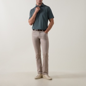 Model wearing Peter Millar polo in Pinebrook, styled with stone chinos, brown belt, and cream loafers