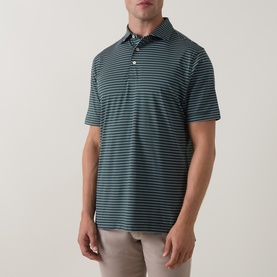 Model wearing Peter Millar polo in Pinebrook, featuring fine horizontal stripes, short sleeves and three-button placket, styled with beige trousers.