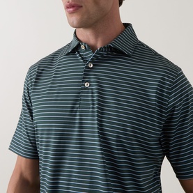Model wearing Peter Millar polo in Pinebrook, featuring fine white horizontal stripes, short sleeves, and a three-button placket.