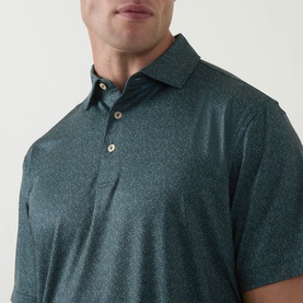 Model wearing Peter Millar polo in Pinebrook, close-up showing tonal speckle print, three-button placket and spread collar.