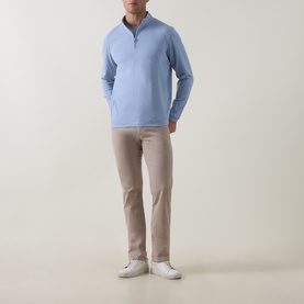 Model wearing Peter Millar Ardent Air Half-Zip Sweatshirt in Lakeside blue, styled with stone chinos and white trainers.