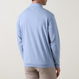 Model wearing Peter Millar Ardent Air Half-Zip Sweatshirt in Lakeside blue, rear view, with beige trousers.